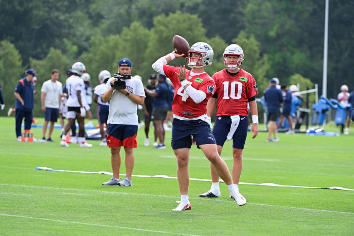 Bailey Zappe throws the football while mac Jones stands behind him and watches